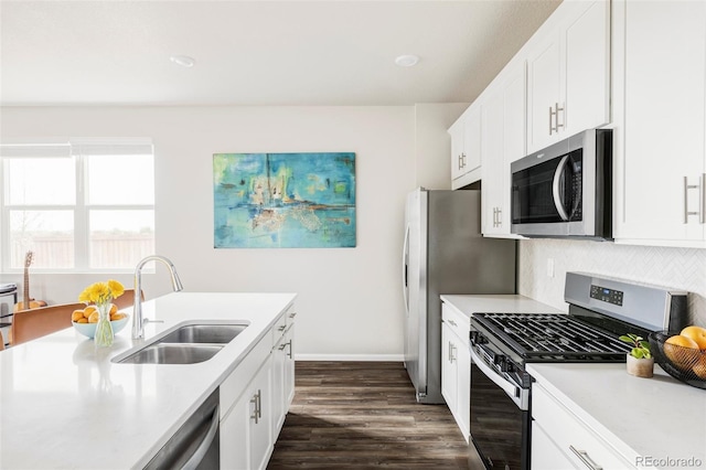 5099 S Robb St, Littleton, CO 80127 - kitchen featuring appliances with stainless steel finishes, a sink, light countertops, dark wood finished floors, and decorative backsplash