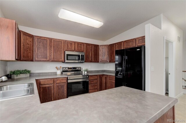 kitchen with sink, stainless steel appliances, vaulted ceiling, and kitchen peninsula