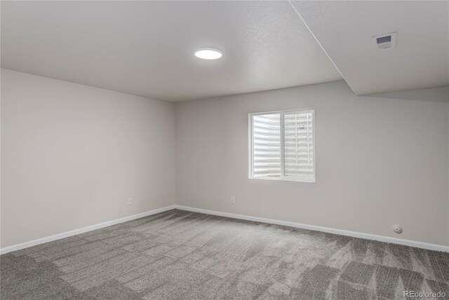 carpeted empty room with a textured ceiling