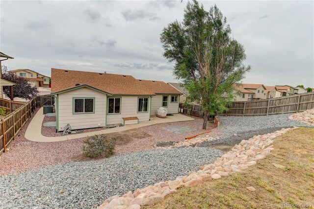 back of property with central AC unit and a patio area