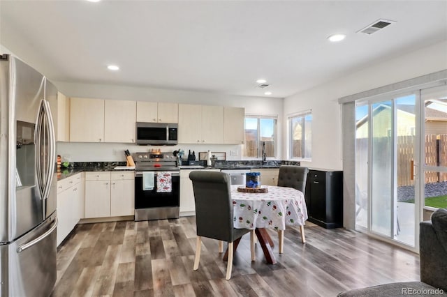 kitchen with cream cabinetry, wood-type flooring, stainless steel appliances, and sink