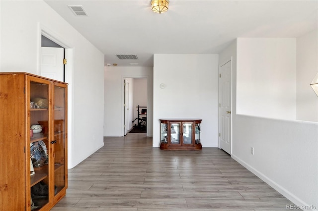 corridor with hardwood / wood-style flooring