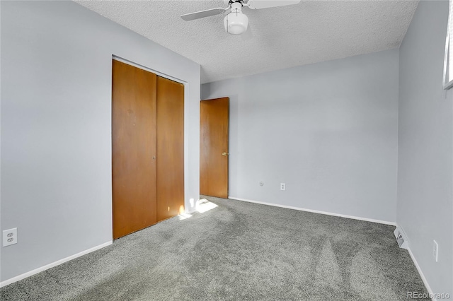 unfurnished bedroom with a textured ceiling, carpet floors, a closet, and ceiling fan