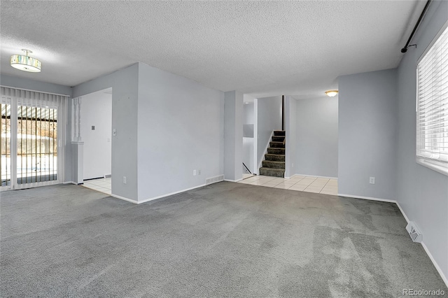 carpeted empty room with a textured ceiling