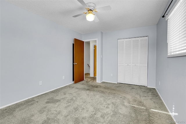 unfurnished bedroom featuring ceiling fan, carpet, a closet, and a textured ceiling