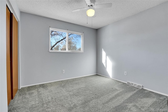 carpeted empty room featuring ceiling fan and a textured ceiling