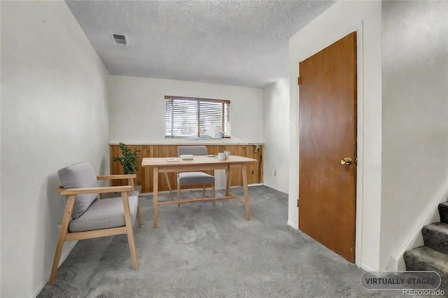 carpeted home office with a textured ceiling