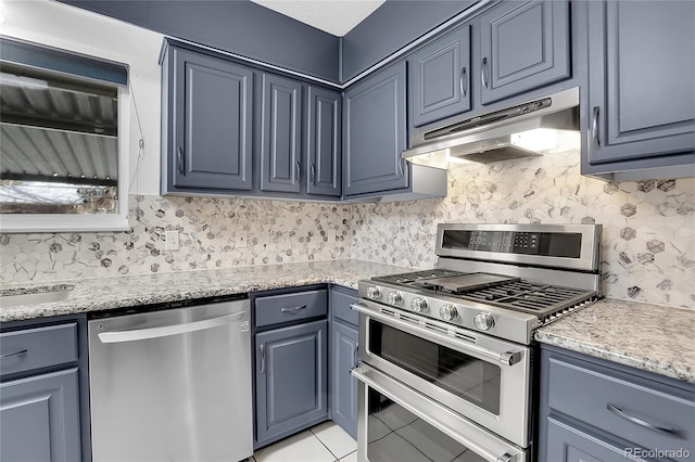 kitchen featuring light stone counters, light tile patterned floors, stainless steel appliances, and sink