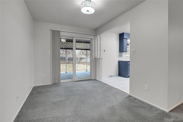 unfurnished room with light carpet, visible vents, and baseboards