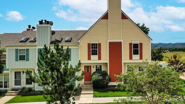 6796 S Independence St, Littleton, CO 80128 - view of front facade with a chimney, a mountain view, board and batten siding, and a shingled roof