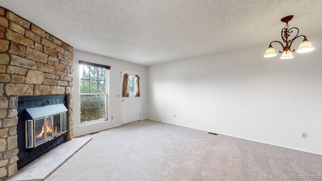 6796 S Independence St, Littleton, CO 80128 - unfurnished living room with a stone fireplace, a chandelier, carpet flooring, and a textured ceiling
