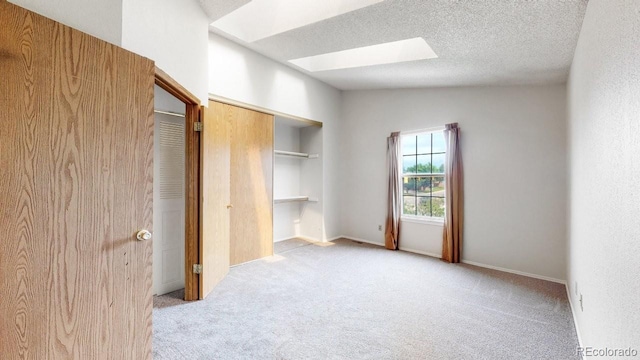 6796 S Independence St, Littleton, CO 80128 - unfurnished bedroom featuring a skylight, carpet floors, and a textured ceiling