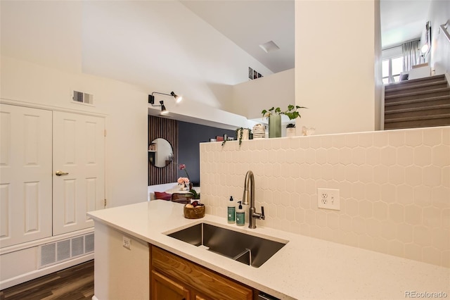 kitchen featuring sink, backsplash, dark hardwood / wood-style floors, and lofted ceiling