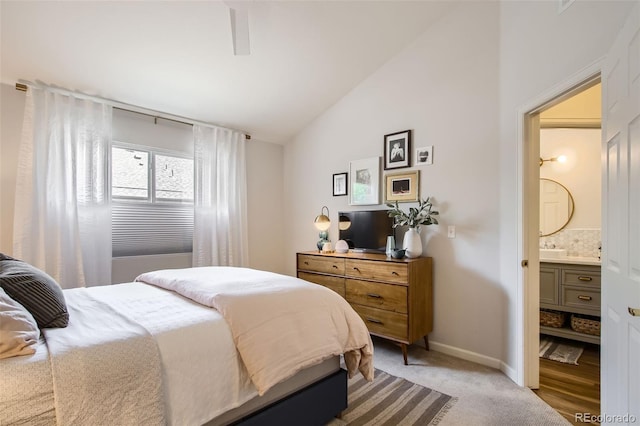 carpeted bedroom with vaulted ceiling and ensuite bath