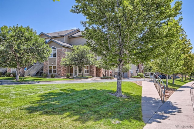 view of property hidden behind natural elements with a front lawn