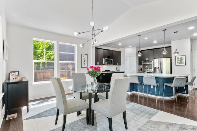 dining space featuring a chandelier, light wood finished floors, recessed lighting, lofted ceiling, and baseboards