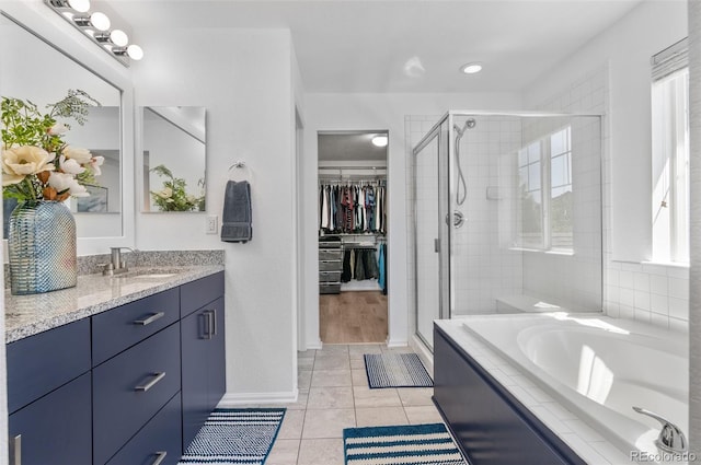 bathroom with a stall shower, vanity, and healthy amount of natural light