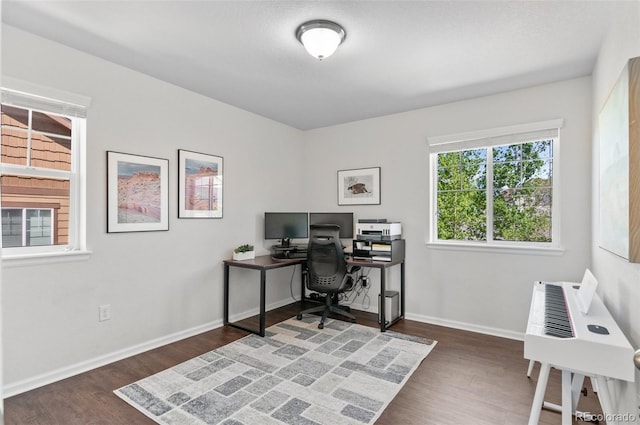 office area with dark wood-style flooring and baseboards
