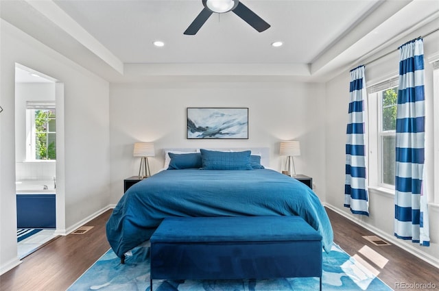 bedroom with wood finished floors, a raised ceiling, baseboards, ceiling fan, and recessed lighting