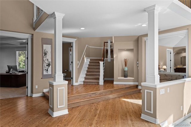 interior space featuring hardwood / wood-style floors and ornate columns