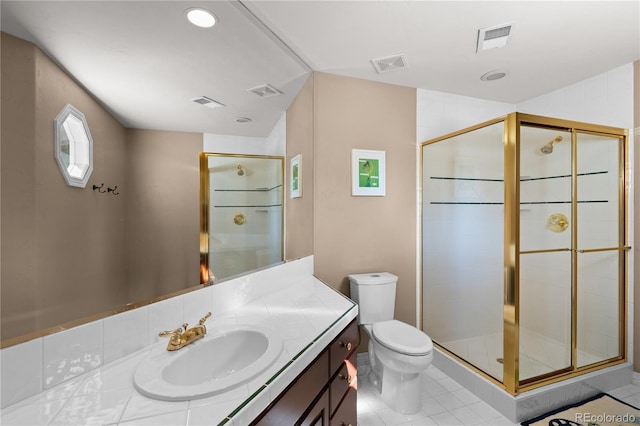 bathroom featuring vanity, tile patterned flooring, toilet, and walk in shower