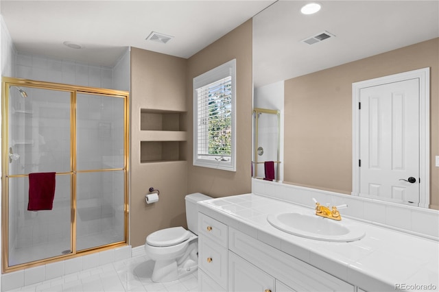 bathroom with toilet, vanity, and a shower with shower door