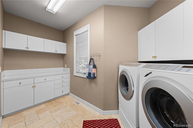 washroom with independent washer and dryer and cabinets