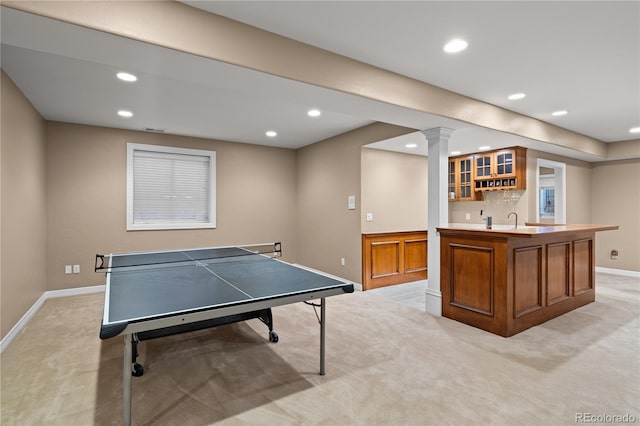 rec room with wet bar and light carpet