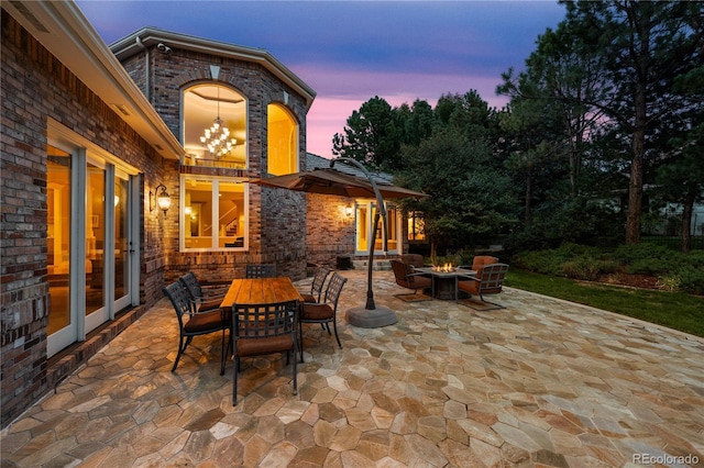 patio terrace at dusk featuring a fire pit