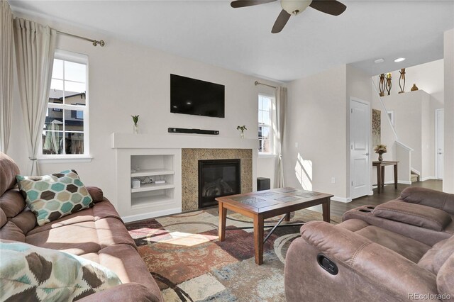 3266 Riverwood Way, Castle Rock, CO 80109 - living area featuring built in shelves, baseboards, a ceiling fan, stairs, and a tile fireplace