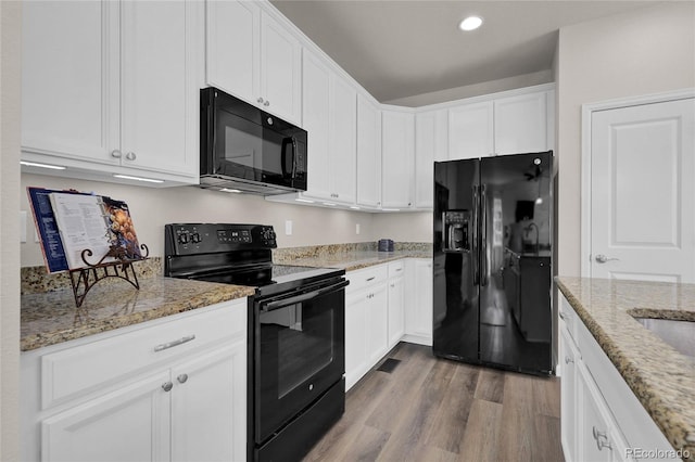 3266 Riverwood Way, Castle Rock, CO 80109 - kitchen with white cabinets, wood finished floors, light stone countertops, and black appliances
