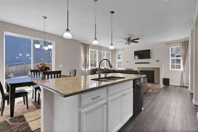 3266 Riverwood Way, Castle Rock, CO 80109 - kitchen featuring ceiling fan with notable chandelier, a fireplace, stone countertops, black dishwasher, and a sink