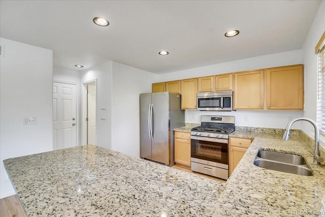9905 Aftonwood St, Highlands Ranch, CO 80126 - kitchen with stainless steel appliances, light brown cabinetry, light stone counters, recessed lighting, and a peninsula