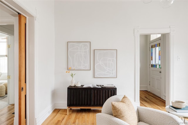 sitting room with baseboards, plenty of natural light, and light wood-type flooring