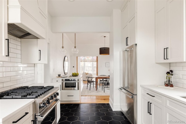 kitchen featuring light countertops, premium appliances, custom exhaust hood, and white cabinetry