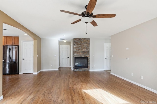 16351 E 104th Pl, Commerce City, CO 80022 - unfurnished living room featuring ceiling fan, light wood finished floors, baseboards, and arched walkways