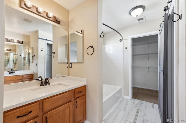 16351 E 104th Pl, Commerce City, CO 80022 - bathroom with shower / tub combination, marble look tile flooring, vanity, and a walk in closet