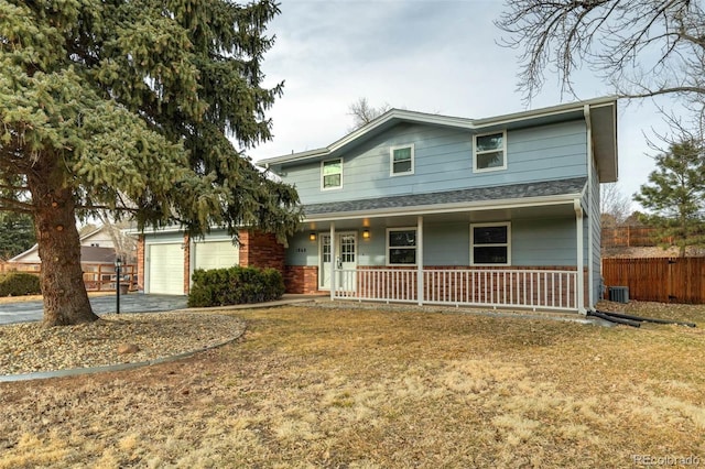 view of front property featuring a garage, a front yard, a porch, and central air condition unit