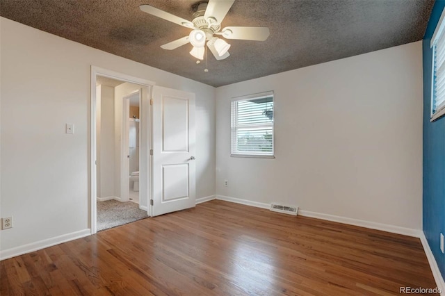 interior space with a textured ceiling, ceiling fan, and hardwood / wood-style flooring