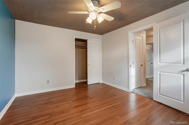 unfurnished bedroom with ceiling fan, wood-type flooring, a closet, and a textured ceiling