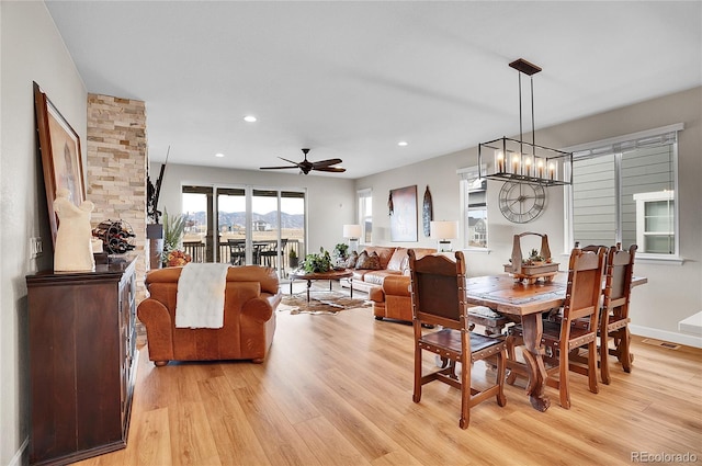 dining area with recessed lighting, baseboards, ceiling fan with notable chandelier, and light wood finished floors