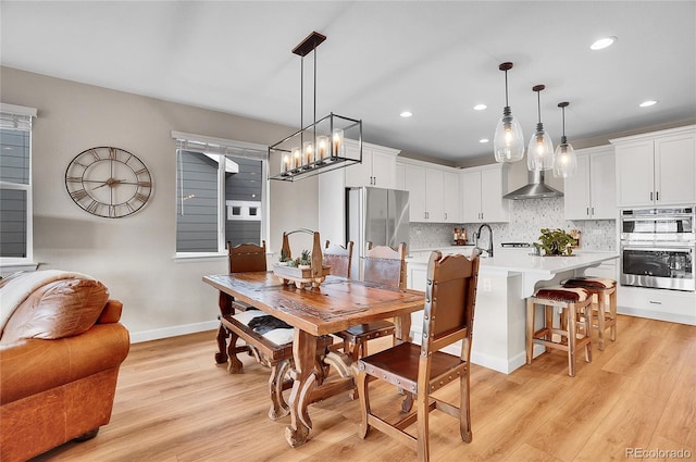 dining room featuring recessed lighting, light wood-type flooring, and baseboards