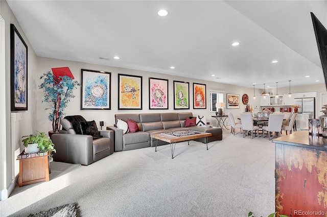 carpeted living area featuring visible vents and recessed lighting