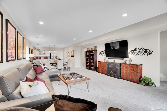 carpeted living room featuring recessed lighting, baseboards, and a glass covered fireplace