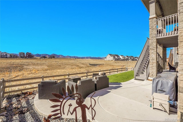 view of patio / terrace featuring stairs, fence, and a mountain view