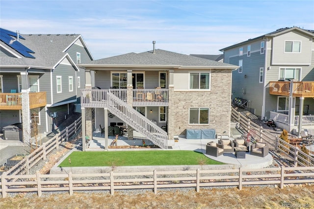 rear view of property featuring a fenced backyard, an outdoor living space, and a patio