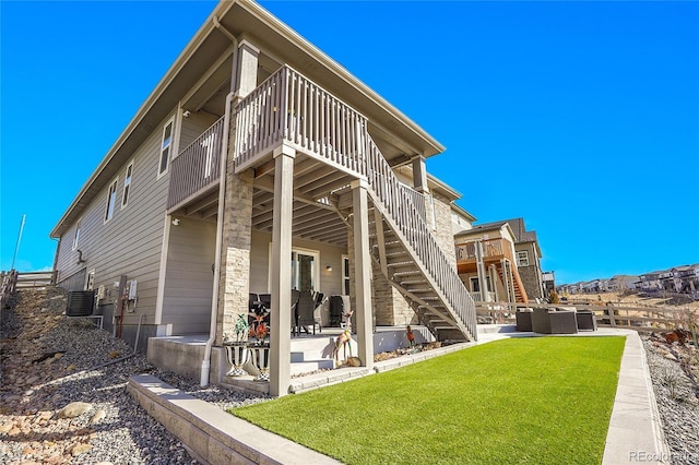 back of property with a lawn, central AC unit, stairs, and a patio area