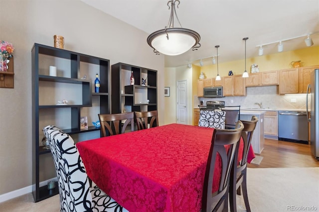 dining space with track lighting and baseboards