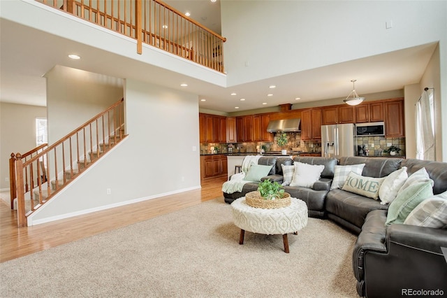 23427 Song Bird Hills Pl, Parker, CO 80138 - living area with a towering ceiling, stairway, light wood-style flooring, recessed lighting, and baseboards
