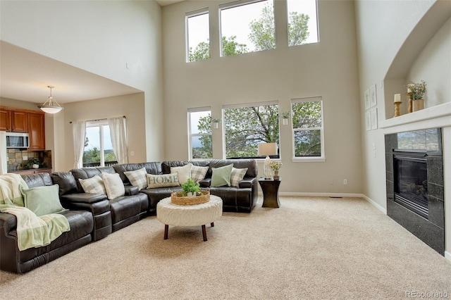 23427 Song Bird Hills Pl, Parker, CO 80138 - living room featuring a towering ceiling, carpet, a tiled fireplace, and baseboards